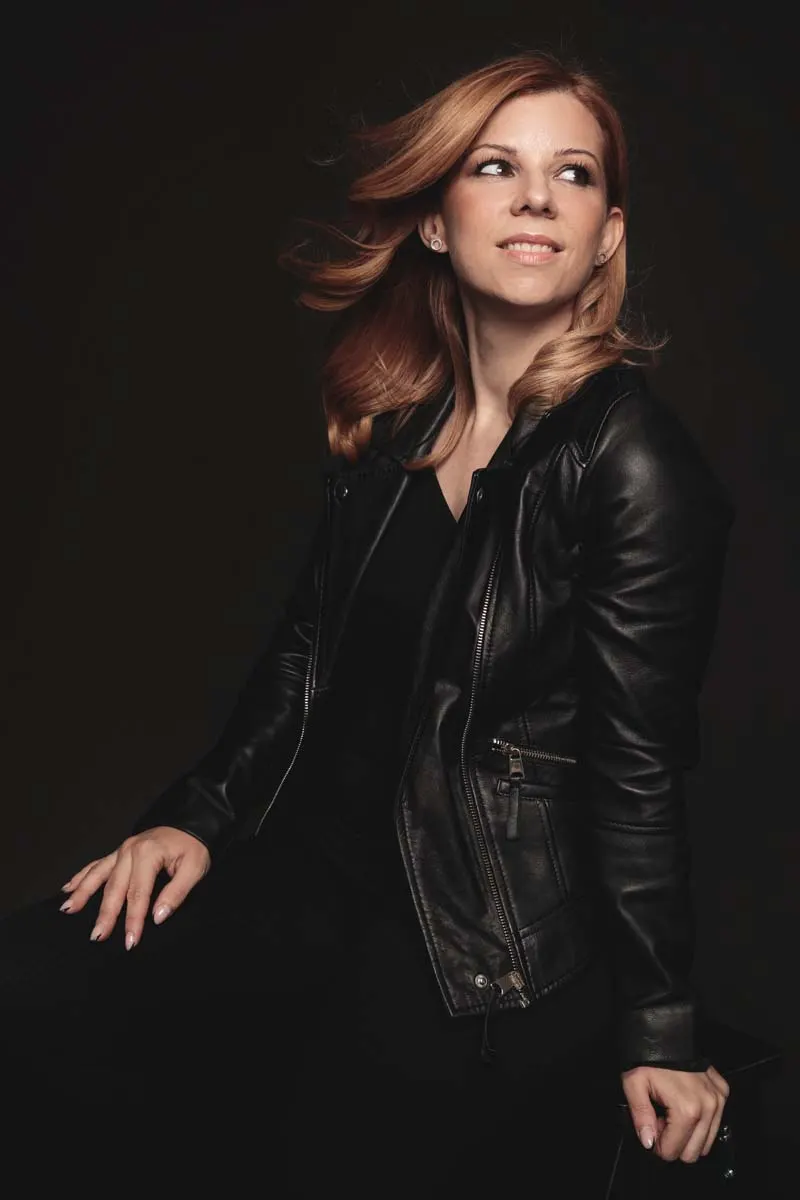 Retrato laboral de una mujer con chaqueta sobre fondo negro