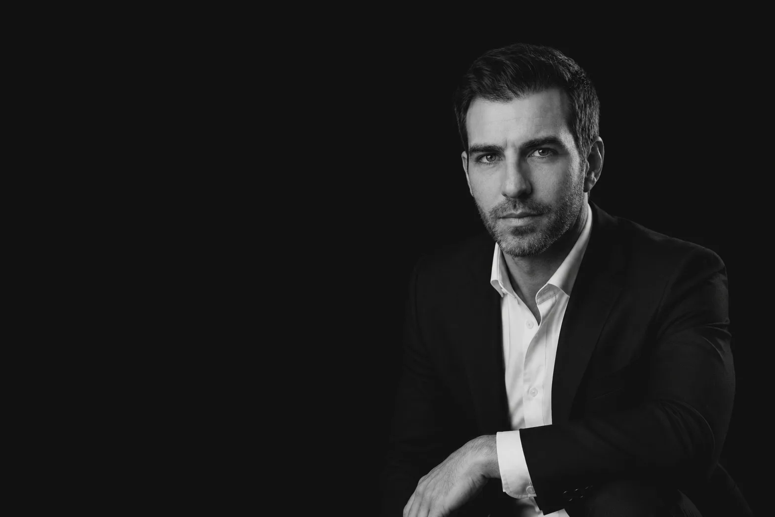 Retrato corporativo en blanco y negro de un hombre con traje y camisa blanca