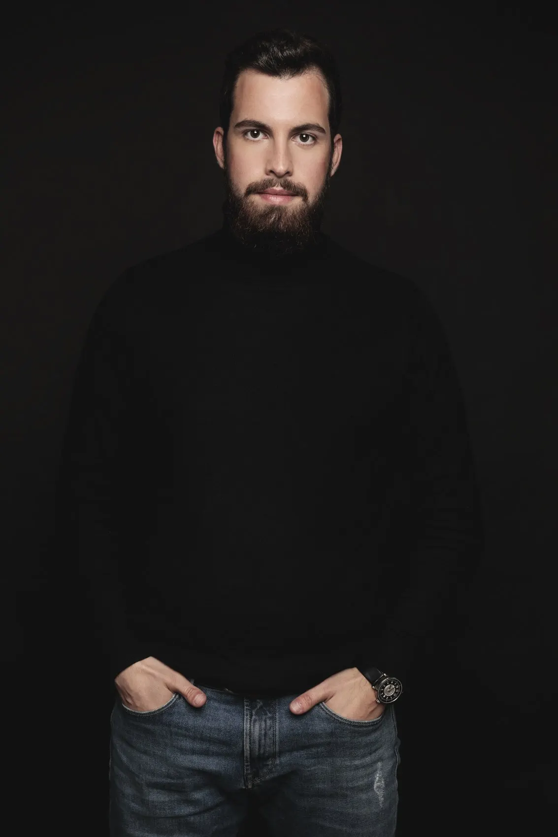 Retrato laboral masculino con jersey negro sobre fondo negro