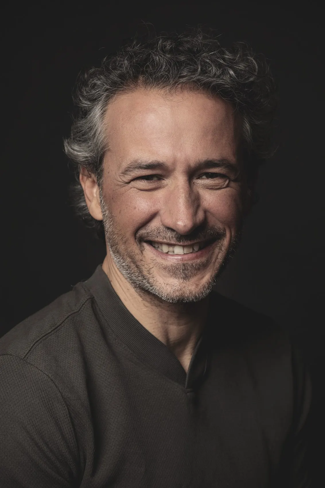 Retrato corporativo de hombre sonriente con canas