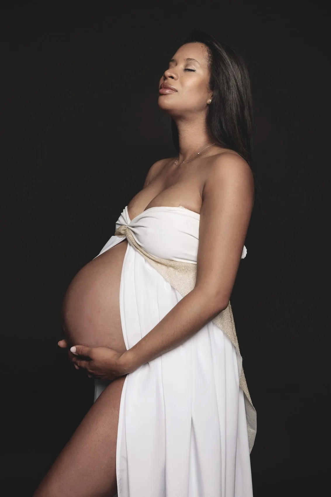 Sesión premamá con vestido blanco y banda dorada