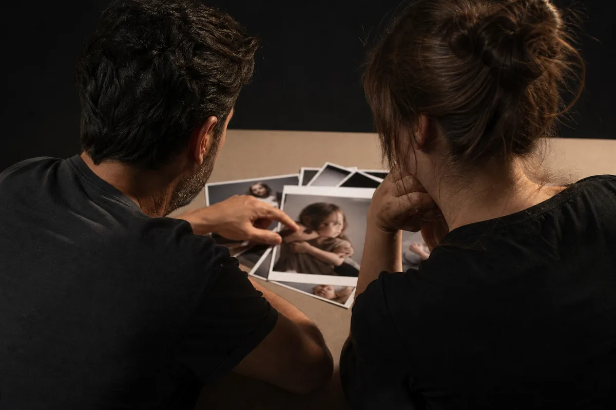Dos personas revisando copias impresas extendidas sobre una mesa