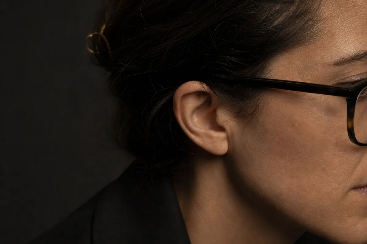 Detalle de la patilla de las gafas apoyada más baja detrás de la oreja