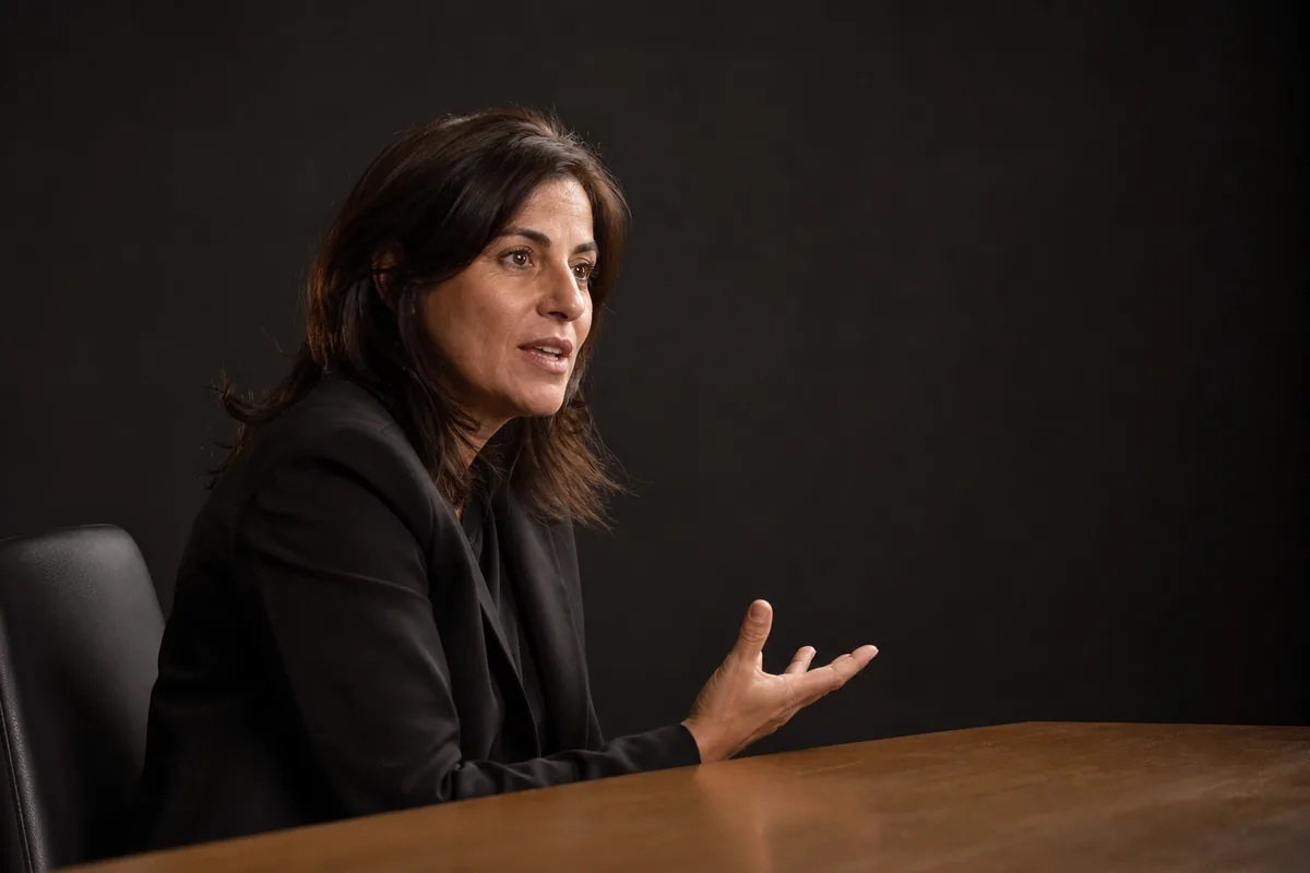Directora de casting en su despacho, girada de la mesa a media conversación