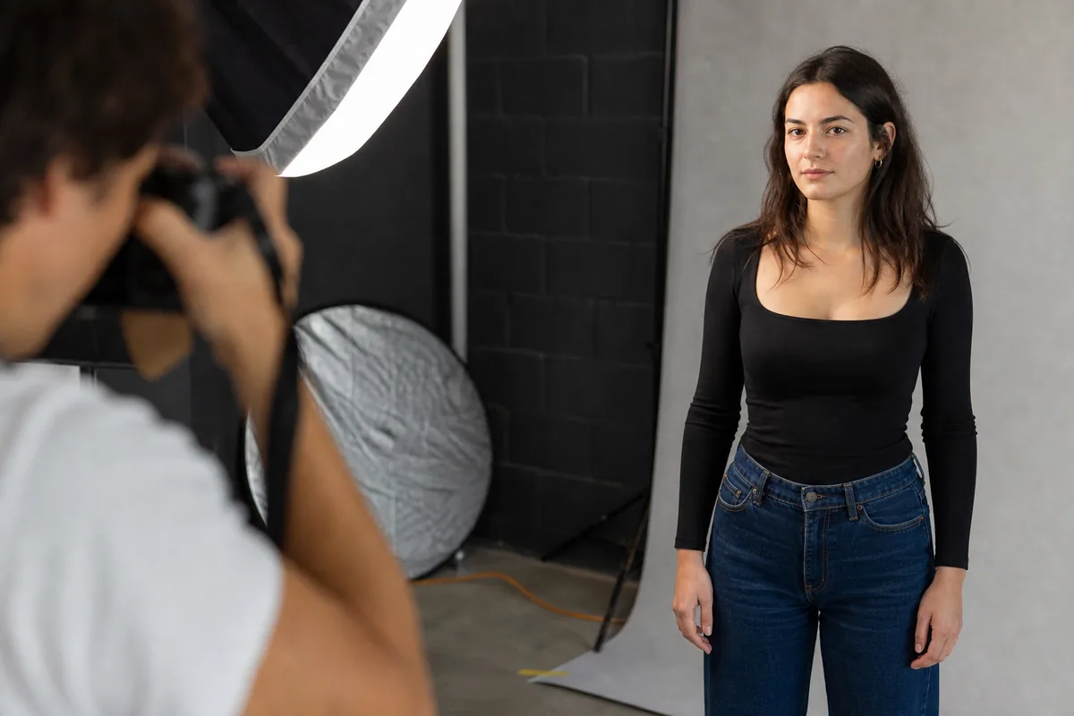 Modelo posando en el ciclorama vista por encima del hombro del fotógrafo