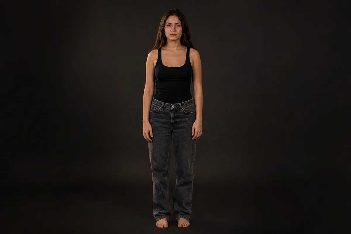 Foto tipo test de cuerpo entero: fondo liso, brazos a los lados, sin expresión