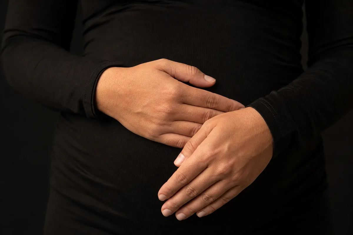 Manos apoyadas sobre la tela a la altura del vientre en una sesión premamá