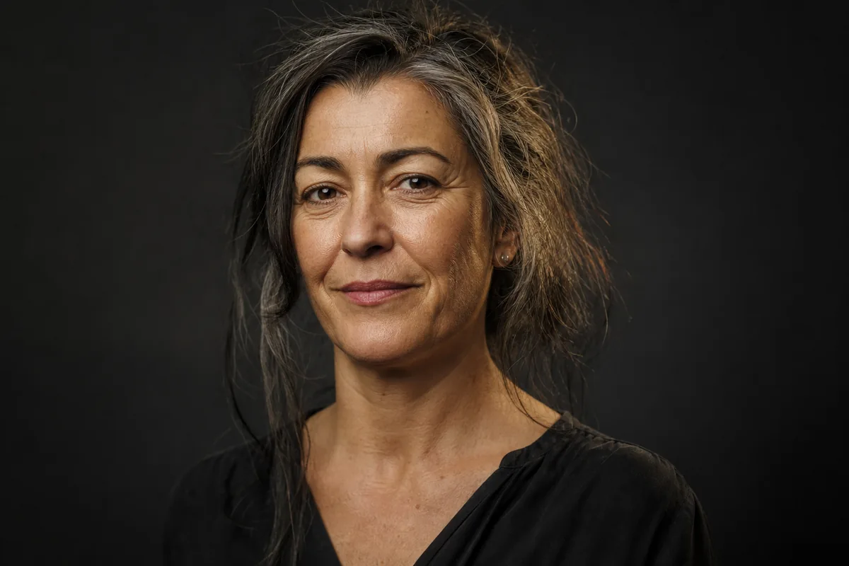 Retrato de mujer con canas visibles y luz suave, sin suavizar la piel