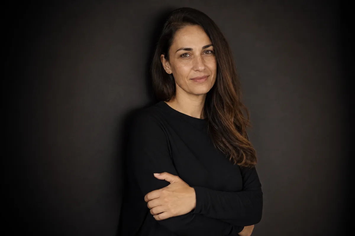 La misma modelo en registro de book, apoyada en el fondo y con media sonrisa