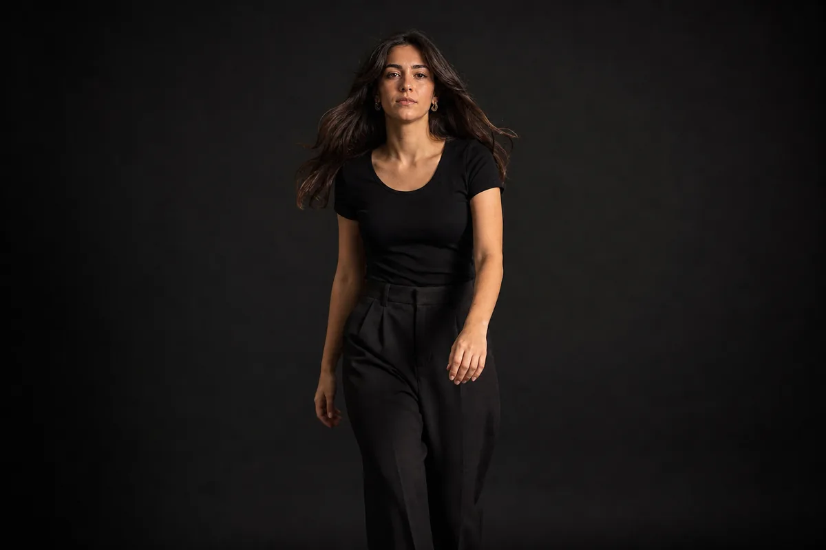 Modelo dando un paso hacia la cámara con el pelo en movimiento